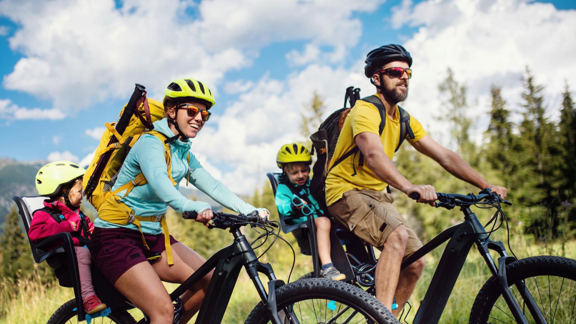 Family biking outdoors with children in bike seats.